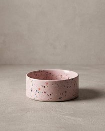 Two round, speckled pet food bowls in pink color. The bowls appear to be made of ceramic or a similar material.