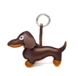 Keychain in the shape of a dark brown and silver dachshund dog, with a metal ring for attaching to keys or bags.