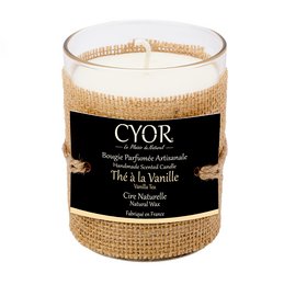 A natural, vanilla-scented candle in a glass container with a burlap wrap. The candle is labeled "CYOR" and "Thé à la Vanille" (Tea with Vanilla).