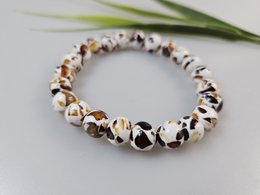  Epoxy and amber gemstone bracelet with a mix of natural and earthy tones, featuring a unique and textured design.
