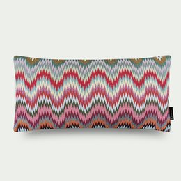 Decorative pillow with a vibrant, multicolored zigzag pattern in shades of pink, gray, and blue. The pillow has a rectangular shape and a soft, plush texture, making it a stylish and comfortable addition to any kids' room.