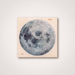 Circular puzzle depicting the moon with craters and surface details. Puzzle pieces in hands against a pink background.