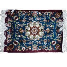 A handmade Persian Bokhara rug with a vibrant, intricate floral pattern in shades of blue, red, and white. The rug has a plush, woolen construction and decorative fringe along the edges.