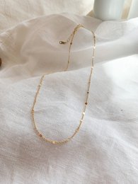 A delicate gold-toned necklace with a simple chain design, suitable for everyday wear.