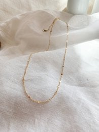 A delicate gold-toned necklace with a simple chain design, suitable for everyday wear.