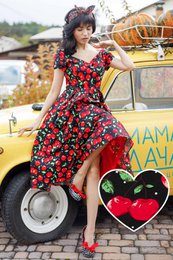  A vibrant, off-the-shoulder cherry blossom print dress with a flared, swing silhouette. The dress features a fitted bodice and a full, flared skirt. The model is wearing a red headband and sunglasses, adding a retro, pin-up style.
