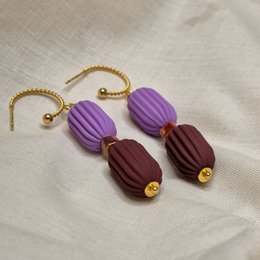 Statement earrings with purple and brown ribbed oval shapes, featuring a gold-tone chain.