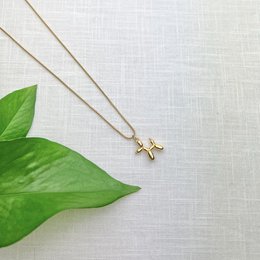 Gold-tone metal chain necklace with a balloon poodle charm.
