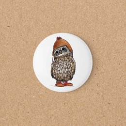 Owl magnet with brown feathers, wearing orange hat and glasses, round white design.