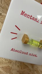 Kachel „Geistig ausgeglichen? Auf keinen Fall.' – mit einer echten Wasserwaage