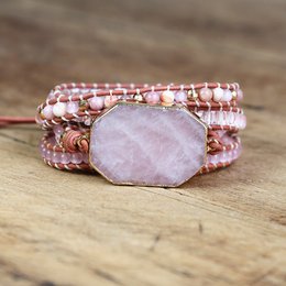 A rose quartz wrap bracelet with beaded strands in shades of pink and rose gold. The bracelet features a natural rose quartz stone as the focal point, creating a beautiful and feminine accessory.