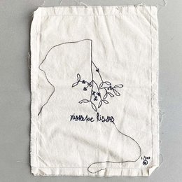  A white fabric bag with a hand-drawn mistletoe design and the text "Mistletoe Kisses" printed on it. The bag appears to be a decorative standing decoration or ornament.