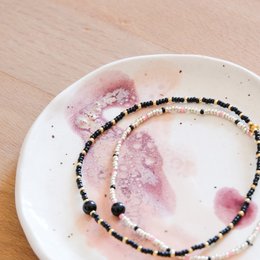 Silver, black, and pink onyx bracelet with charms.