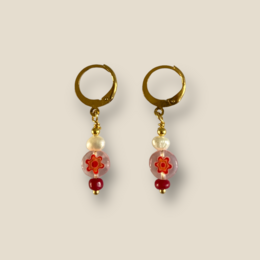 Gold-tone hoop earrings with red and white beaded accents.
