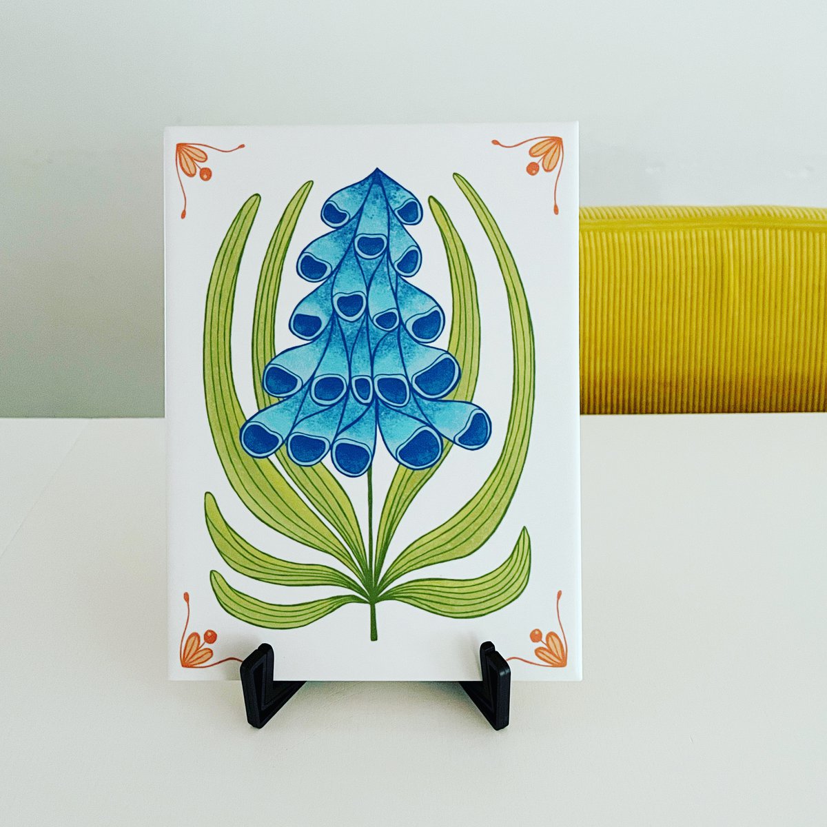 Toffe tegel met blauwe bloem en oranje details