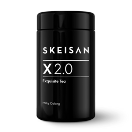 Flavored oolong tea in a black glass container with the product name "X 2.0 Tea Glass: Flavored Oolong Tea" and the brand "SKEISAN" printed on it. The tea leaves are visible in the second image.