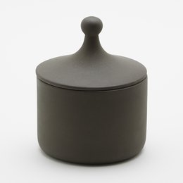 A round, tall, matte black ceramic storage jar with a lid.