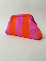 Colorful striped and floral patterned small pouches, vibrant pink orange purple, clutch style accessories.
