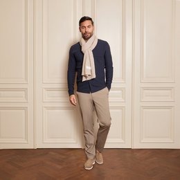 Beige knitted scarf with label, suitable for casual or formal wear.