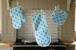 Blue and white patterned oven mitts and pot holder with elephant design.