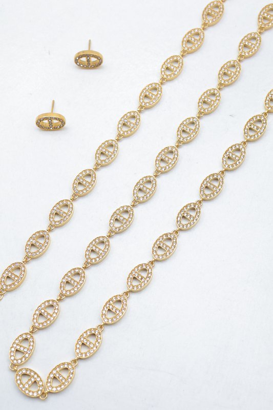 Ensemble assorti comprenant un collier, un bracelet en chaîne et une paire de boucles d'oreilles puces. Chaque bijou est composé d'une succession de maillons en forme de maille marine entièrement pavés de petits strass scintillants.