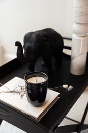 Ceramic candle with Tonka and Patchouli scents, black in color, with a modern, minimalist design.