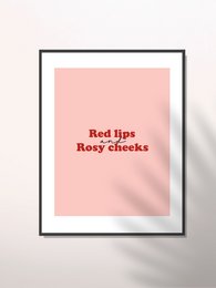 A minimalist wall art print featuring the text "Red lips Rosy cheeks" in a bold, red font against a soft pink background.