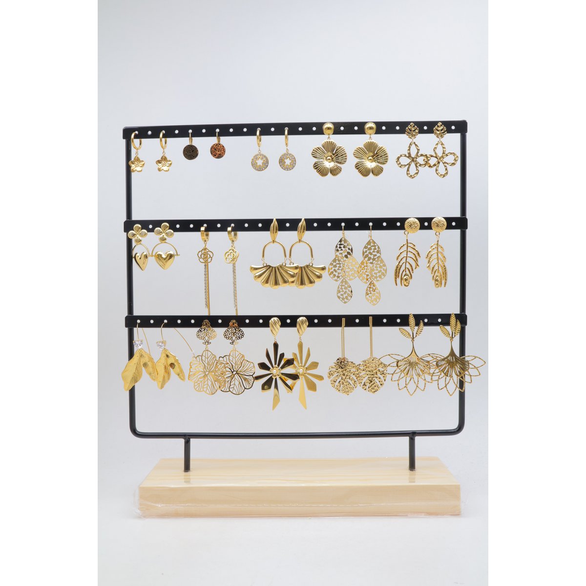 Lot de 15 paires de boucles d'oreilles assorties en acier inoxydable, présentées sur un présentoir métallique avec socle en bois.