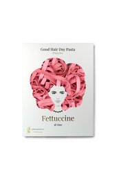 Fettuccine al vino pasta with red chili peppers, parmesan cheese, and a wooden spoon on a red background.