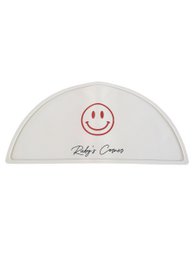 Beige silicone placemat with smiley face design, semicircle shape, baby care product