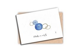 A greeting card with a simple watercolor design of blue and white circles, accompanied by the handwritten text "make a wish".