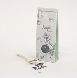 A tall, round glass canister filled with dark tea leaves, labeled "Thee 'Vreugde schenken'" on a white background.