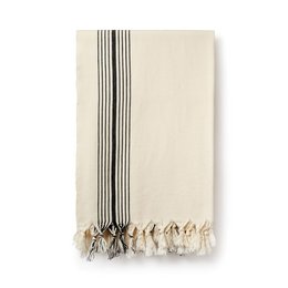 Cream-colored peshtemal towel with black stripes and tasseled edges, suitable for bathroom use.