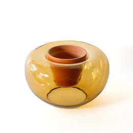 "Amber glossy round bulbous plant pot vase with wide opening, smooth curved shape"