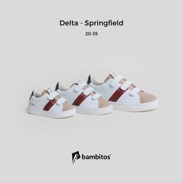 White casual sneakers with velcro straps, suitable for kids' sports activities. Features a mix of colors including red and navy blue accents.