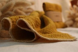 Organic cotton cloth napkin in pink and mango-yellow colors, with a soft, textured surface.