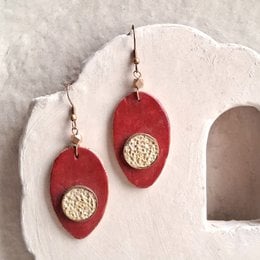 Red oval paper-mache earrings with cream textured center detail, lightweight statement jewelry, handmade artisan style