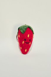 A red, strawberry-shaped keychain with a smiling face.