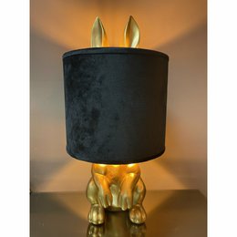 A black velvet table lamp with gold bunny ears and a black velvet shade.