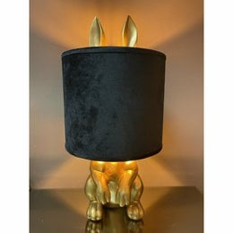 A black velvet table lamp with gold bunny ears and a black velvet shade.