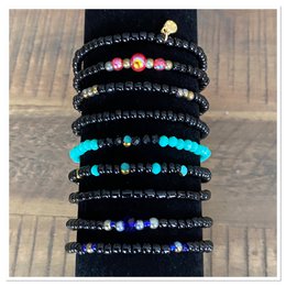 A set of black beaded bracelets with colorful accents, including turquoise, purple, and multicolored beads. The bracelets have a stacked, layered appearance and appear to be made of high-quality materials.