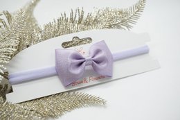 Nylon hairband with metallic satin baby bow in various colors including antique white, cream, tan, pink, pearl pink, rose pink, beauty, red, ocean blue, blue topaz, navy blue, lilac, grape, amethyst, green, gold, shell grey, and black. Suitable for kids' hair accessories.