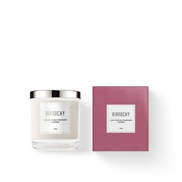Peony-scented candle in a white glass container with a pink box. The candle has a round, tall shape and is made of wax.