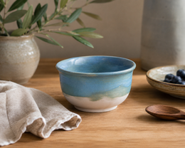 Rustic ceramic bowl with a rusty, earthy tone and a simple, minimalist design. Suitable for serving food or as a decorative piece.