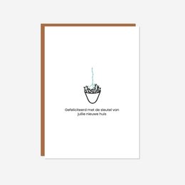 A greeting card with a simple black and white illustration of a hand holding a house-shaped balloon. The text on the card reads "Congratulations on your new home! Wishing you all the best."