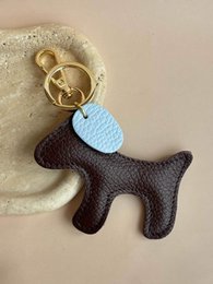 # Product Description
Knitted dog-shaped keychain holder, colorful wool felt, multiple color variants including pink, brown, beige, green, raspberry.