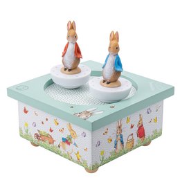 A whimsical music box featuring two dancing Peter Rabbit figurines on a colorful, floral-patterned base.