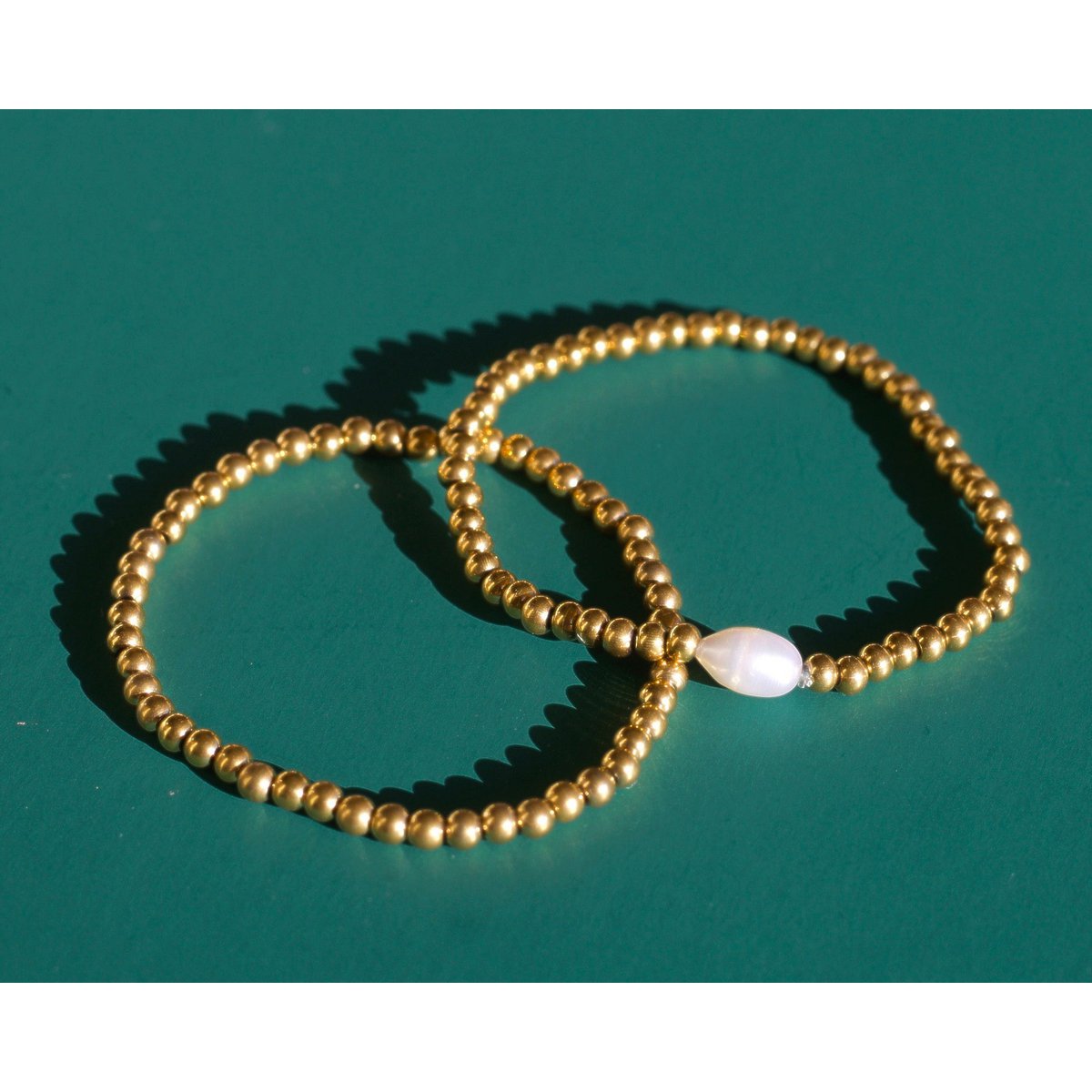 Aquilea - Pile de bracelets en perles d'or