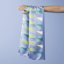 Dutches sjaal Aki 49, a scarf featuring a geometric pattern in shades of green, blue, and gray. The scarf has a soft, lightweight material and a rectangular shape.