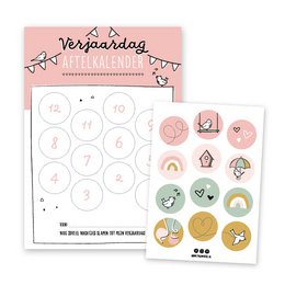 A pink birthday countdown calendar with decals featuring various shapes and designs, including a rainbow, hearts, and other decorative elements. The calendar appears to be designed for children's use.